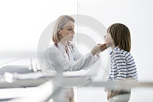 Mature doctor examining patient sitting at hospital