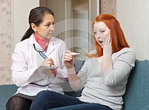 Mature doctor examining teenager patient