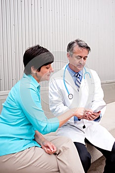 Mature doctor with female patient