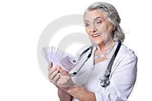 mature doctor with money, posing against white