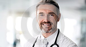 Mature doctor, portrait and happy man in hospital for healthcare, wellness and career in clinic. Face, medical