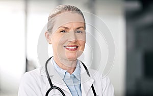 Mature doctor, portrait and happy woman in hospital for healthcare, wellness or career in clinic. Face, medical