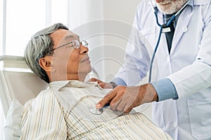 Mature doctor and senior patient in hospital ward.