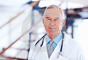 Mature doctor smiling with stethoscope. Portrait of mature male doctor with stethoscope smiling.