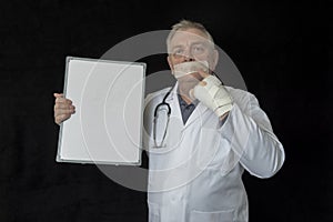 Mature doctor with tape across his mouth photo