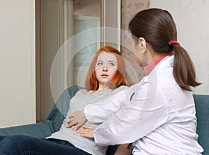 Mature doctor touches belly of teenager