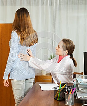 Mature doctor touching behind of female patient