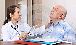 Mature doctor touching neck of man