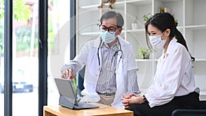 Mature doctor in uniform giving advice to patient in hospital.