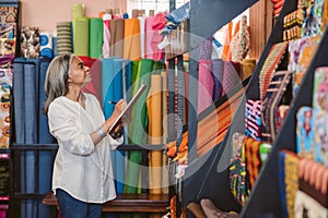 Mature woman doing inventory in her fabric shop