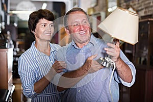 Mature family couple buying antiqua lamp