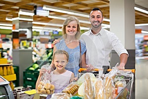 Mature family with kid shopping in hypermarket