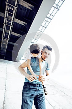Mature father with his son under the bridge having fun together