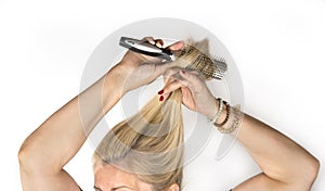 Mature female is combing her hair