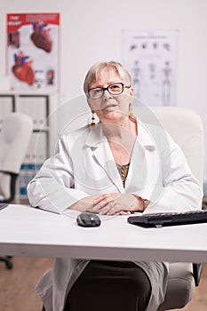 Mature female doctor in clinic cabinet