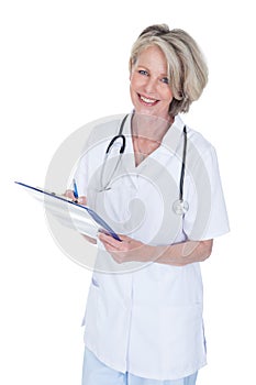 Mature female doctor writing on clipboard