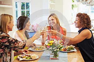 Mature Female Friends Sitting Around Table At Dinner Party