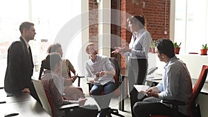 Mature female mentor teach young employees at team business meeting