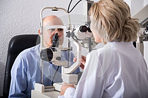 Mature female optician examinating eyesight