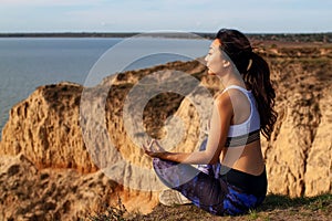 Mature Female Practicing Yoga Pose On Hill