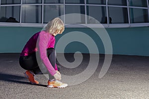 Mature Female Sport Ideas. Active Female Runner Tighten Up Her Shoelaces During Jogging Training Exercise Outdoor