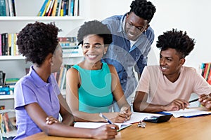 Mature female teacher with african american students