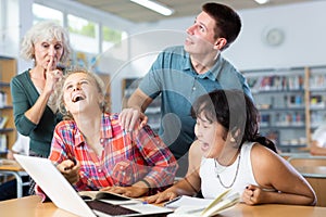 Mature female teacher asks the amused schoolchildren to behave a little quieter