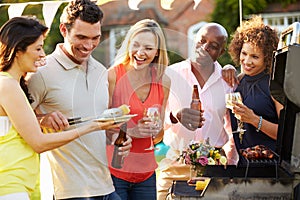 Mature Friends Enjoying Outdoor Summer Barbeque In Garden