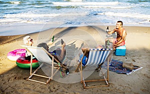 Mature friends having beers at the beach