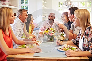 Mature Friends Sitting Around Table At Dinner Party