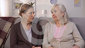 Mature friends supporting and comforting each other sitting on sofa pain of loss