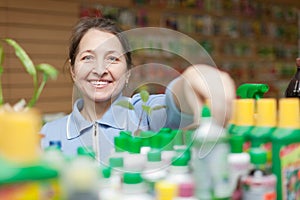 Mature gardener chooses liquid fertilizer