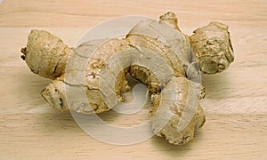 Mature ginger rhizome or root on wooden surface background.