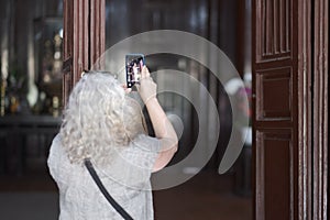 Mature gray-haired woman takes a picture