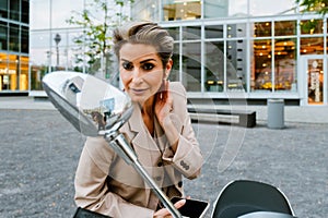 Mature grey woman smiling and looking rear-view mirror on scooter