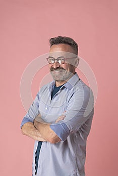 Mature guy laughing in studio on pink background, portrait