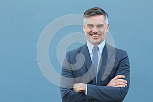 Mature handsome Caucasian businessman smiling with arms crossed