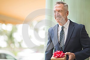 Mature handsome man giving a gift stock photo