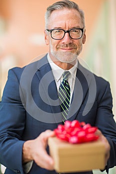 Mature handsome man giving a gift stock photo