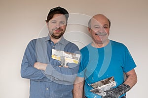 Mature handymen with putty knife smiling looking at camera