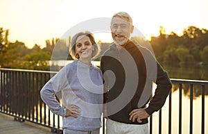 Mature happy couple standing in city park after doing sport workout in nature.