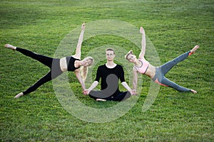 Mature healthy people doing yoga at park. Group people exercising on green grass.