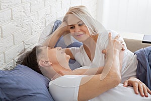 Mature heterosexual beautiful couple lying on bed in bedroom