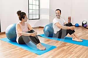 Mature hispanic couple doing excersice and stretching at yoga room