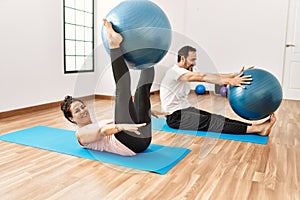 Mature hispanic couple doing excersice and stretching at yoga room