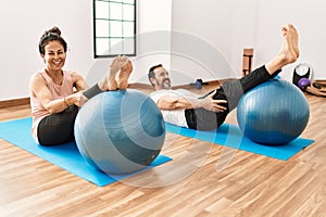 Mature hispanic couple doing excersice and stretching at yoga room