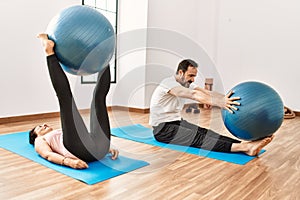 Mature hispanic couple doing excersice and stretching at yoga room