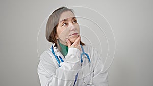 Mature hispanic woman with grey hair doctor standing with doubt expression thinking over isolated white background