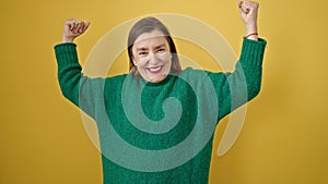 Mature hispanic woman with grey hair smiling confident standing with winner expression over isolated yellow background