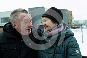 Mature husband and wife spend time together walking down the street in winter